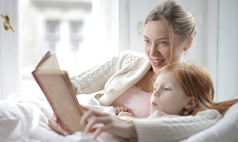 Mother and daughter reading indoors