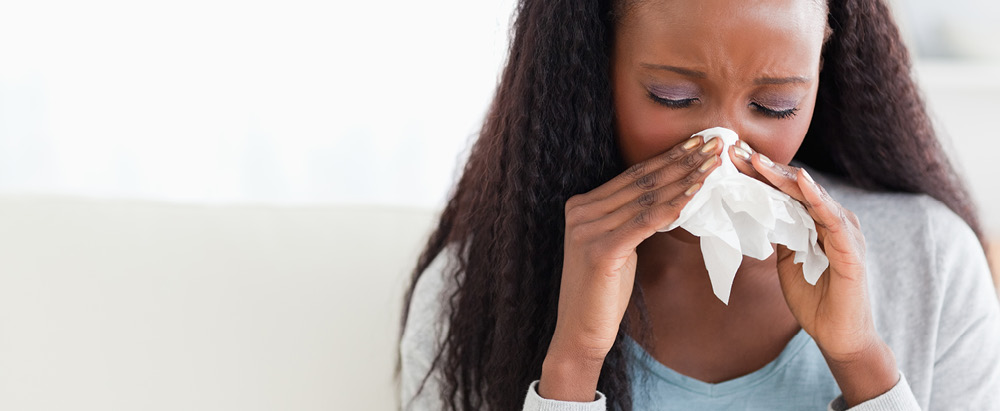 Allergy Season in full force, woman blowing nose