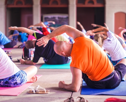 Class of people doing yoga poses on exercise mats