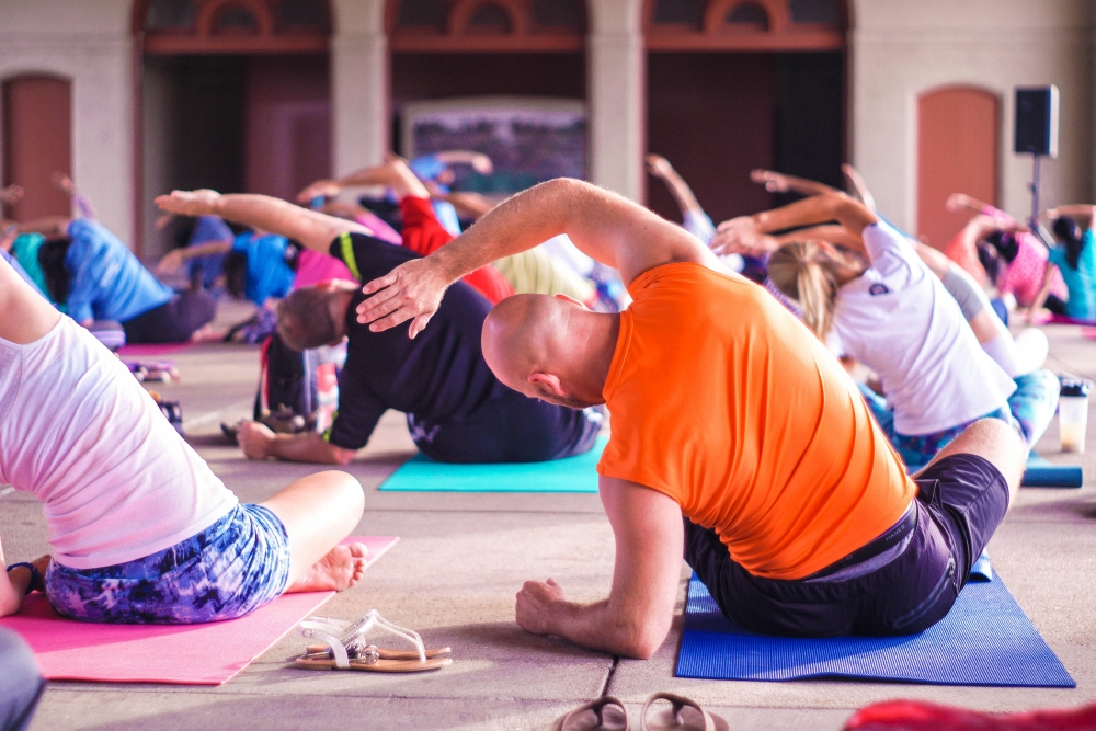 Class of people doing yoga poses on exercise mats