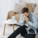Man sneezing next to his over-the-counter allergy medications