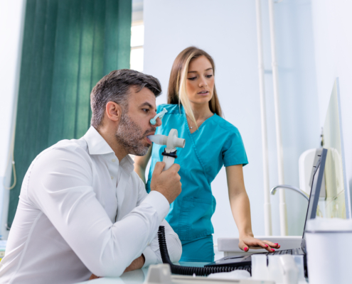 Adult man completing a spirometry test to evaluate lung function for asthma diagnosis