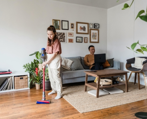 Woman vacuuming to remove dust mites and reduce allergy symptoms.