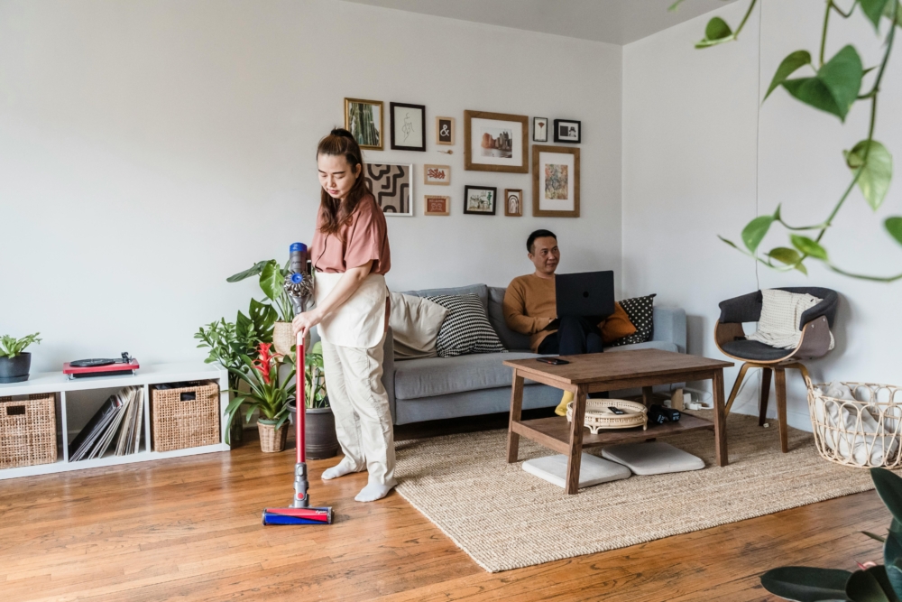 Woman vacuuming to remove dust mites and reduce allergy symptoms.